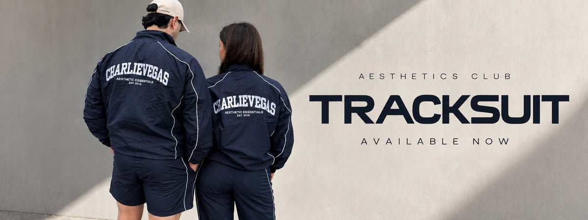 Two models in the navy Aesthetics Club tracksuit, back view, next to the words Aesthetics Club Tracksuit, available now